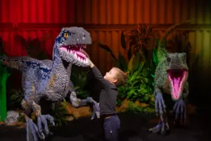 Lapsi tutustumassa LEGOista rakennettuun dinosaurukseen LEGO® Jurassic World -tapahtumassa.