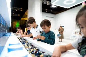 Lapset leikkimässä legoilla LEGO® Jurassic World: The Exhibition -tapahtumassa.